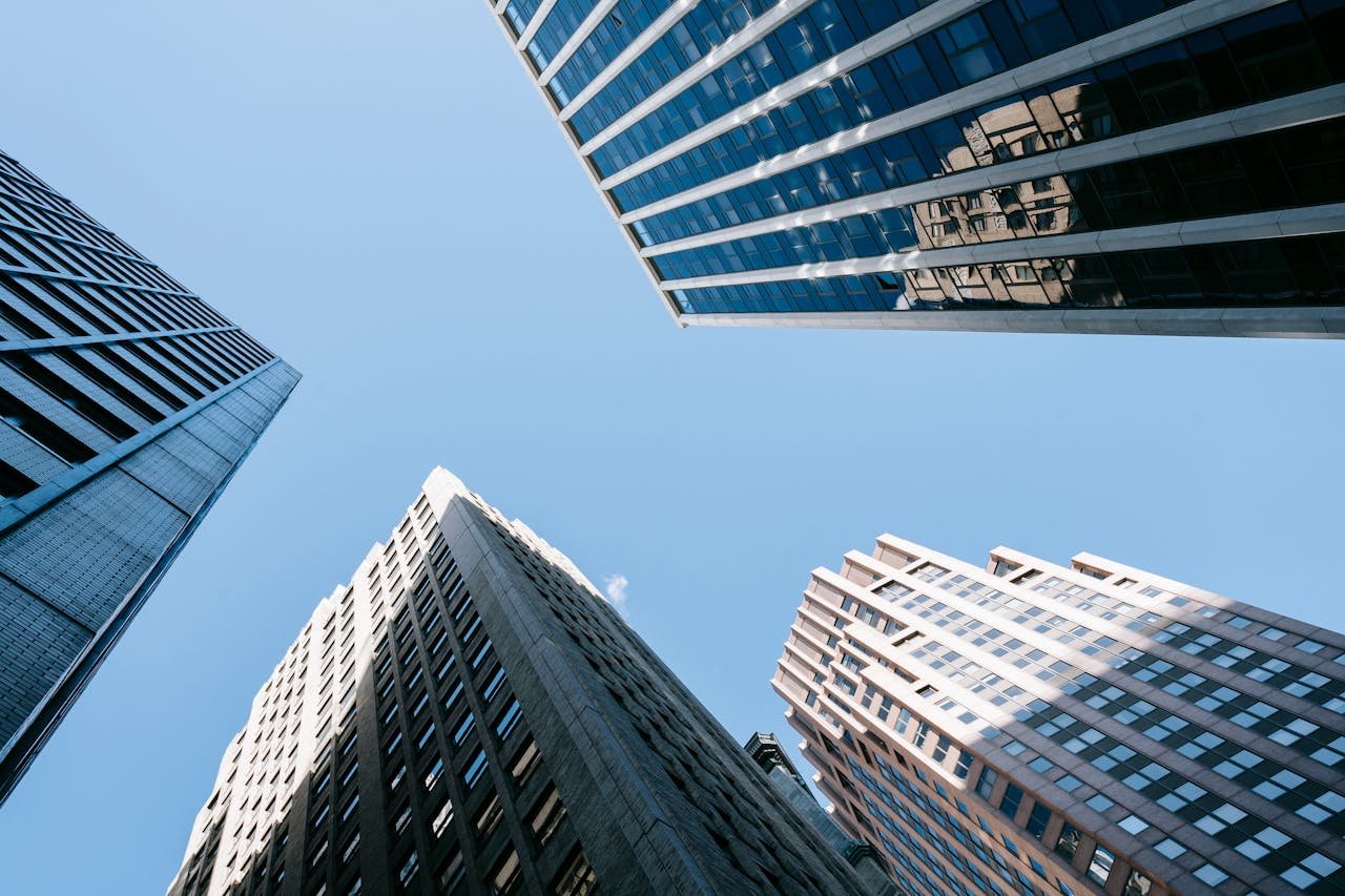 Low angle of high business center with glass mirrored windows near concrete office towers in downtown